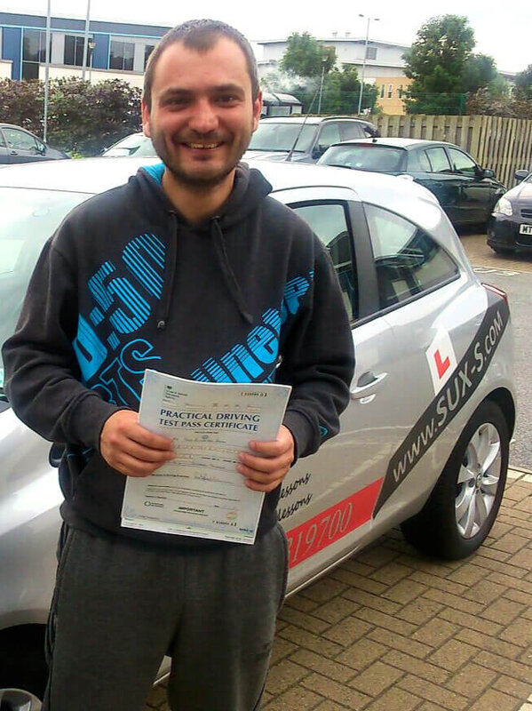 Alexandru from BD7 holding his pass certificate after passing his driving test on his first attempt at Thornbury test centre in Bradford with SUX-S Driving School.