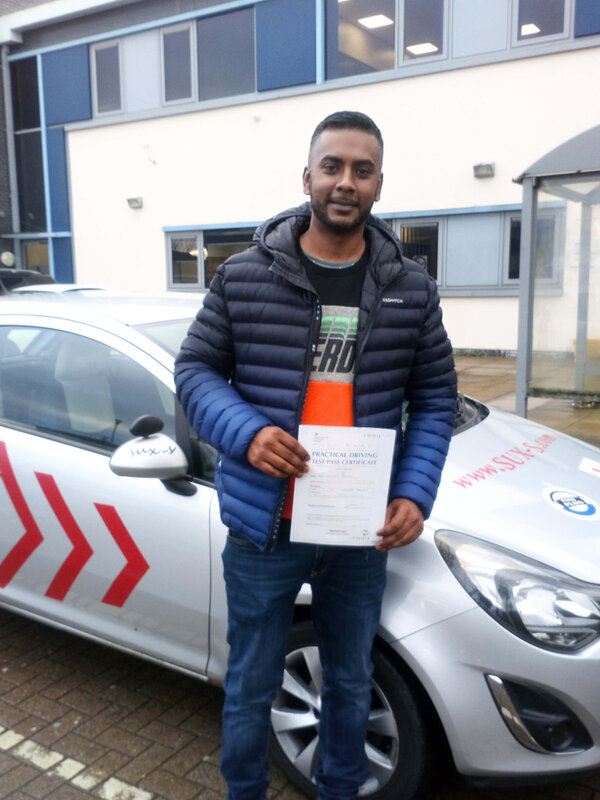 Ashraf from BD3 holding his pass certificate after passing his driving test at Thornbury test centre in Bradford with SUX-S Driving School.