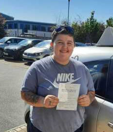 Caitlynn from BD5 smiling with her pass certificate after passing her driving test on her first attempt at Thornbury test centre in Bradford with SUX-S Driving School.