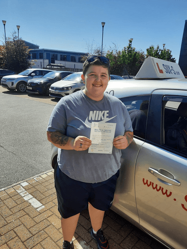Caitlynn from BD8 holding her driving test pass certificate after passing on her first attempt at the Thornbury test centre with SUX-S Driving School.