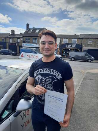Syed from BD6 holding his driving test pass certificate after passing on his first attempt at the Thornbury test centre with SUX-S Driving School.