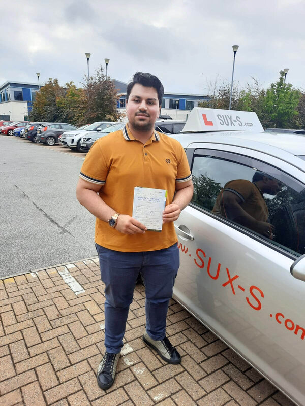 Ibrahim from BD10 holding his pass certificate after passing his driving test on his first attempt at Thornbury test centre in Bradford with SUX-S Driving School.