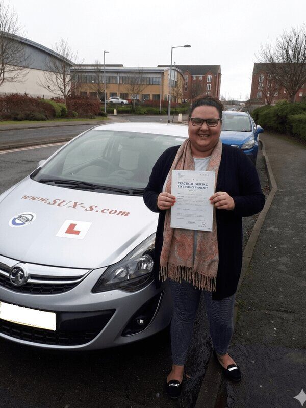 Leonne from BD5 holding her pass certificate after passing her driving test on her second attempt at Heaton test centre in Bradford with SUX-S Driving School.