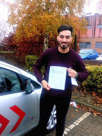 Pradeep from BD3 smiling with his pass certificate after passing his driving test on his first attempt at Thornbury test centre in Bradford with SUX-S Driving School.