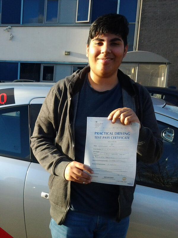 Saj from BD5 smiling with his pass certificate after passing his driving test on his second attempt at Thornbury test centre in Bradford with SUX-S Driving School.