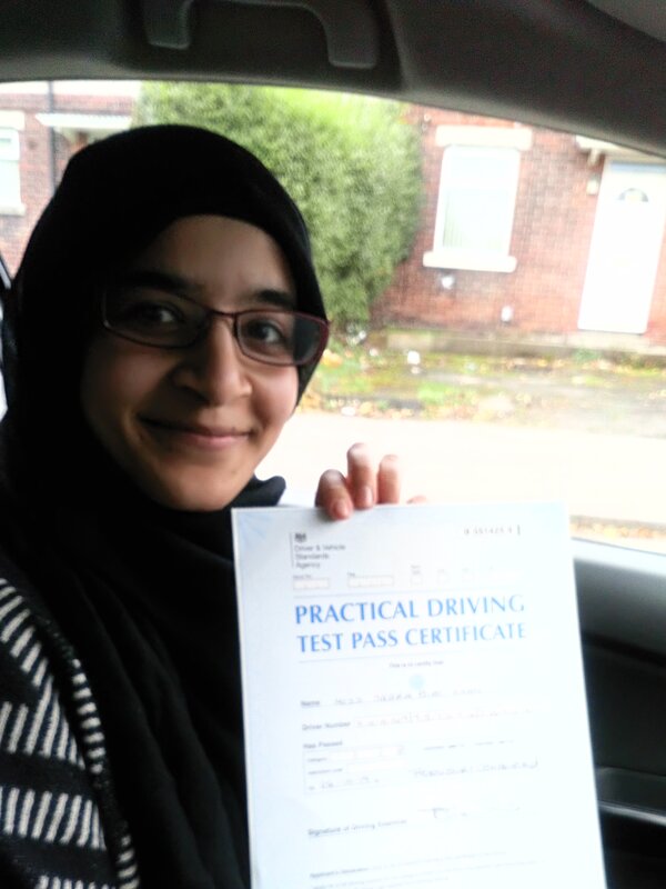 Sarra from BD3 smiling with her pass certificate after passing her driving test with zero driving faults on her second attempt at Thornbury test centre in Bradford with SUX-S Driving School.