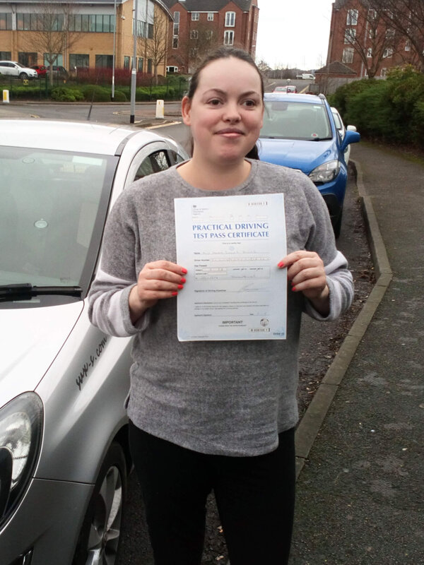 Sarra from BD4 smiling with her pass certificate after passing her driving test on her first attempt at Thornbury test centre in Bradford with SUX-S Driving School.