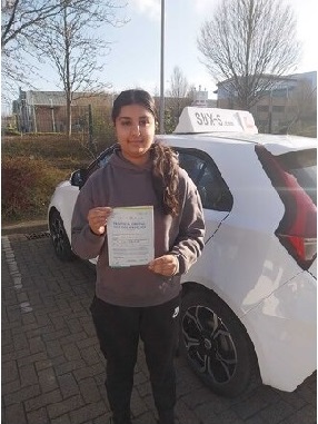 Shabana holding her driving test pass certificate standing next to the SUX-S tuition car in Bradford