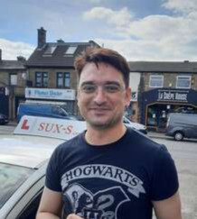 Syed from BD3 holding his pass certificate after passing his driving test on his first attempt at Thornbury test centre in Bradford with SUX-S Driving School.