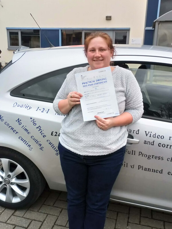 Terresa from BD5 smiling with her pass certificate after passing her driving test on her first attempt at Thornbury test centre in Bradford with SUX-S Driving School.