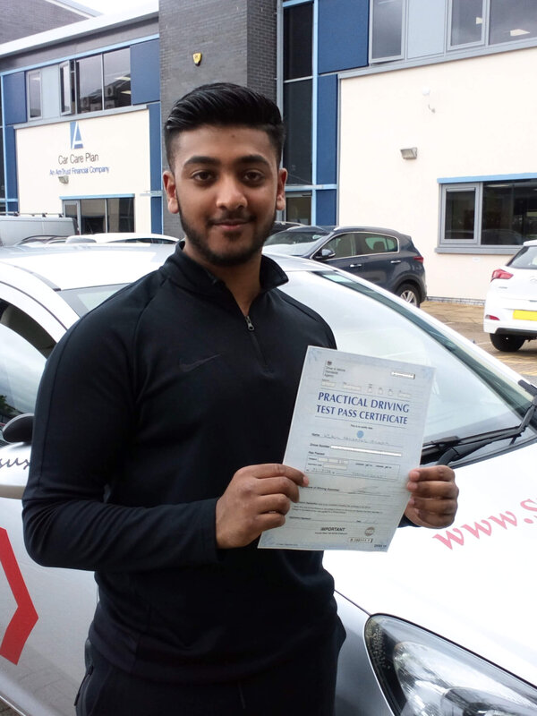 Uzair from BD3 holding his pass certificate after passing his driving test on his first attempt at Thornbury test centre in Bradford with SUX-S Driving School.