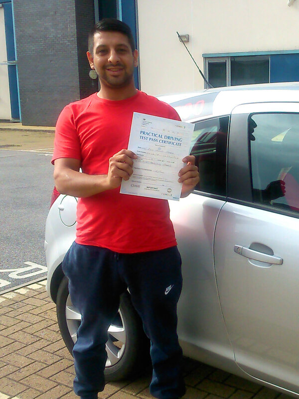 Zain from BD2 smiling with his pass certificate after passing his driving test on his first attempt at Thornbury test centre in Bradford with SUX-S Driving School.